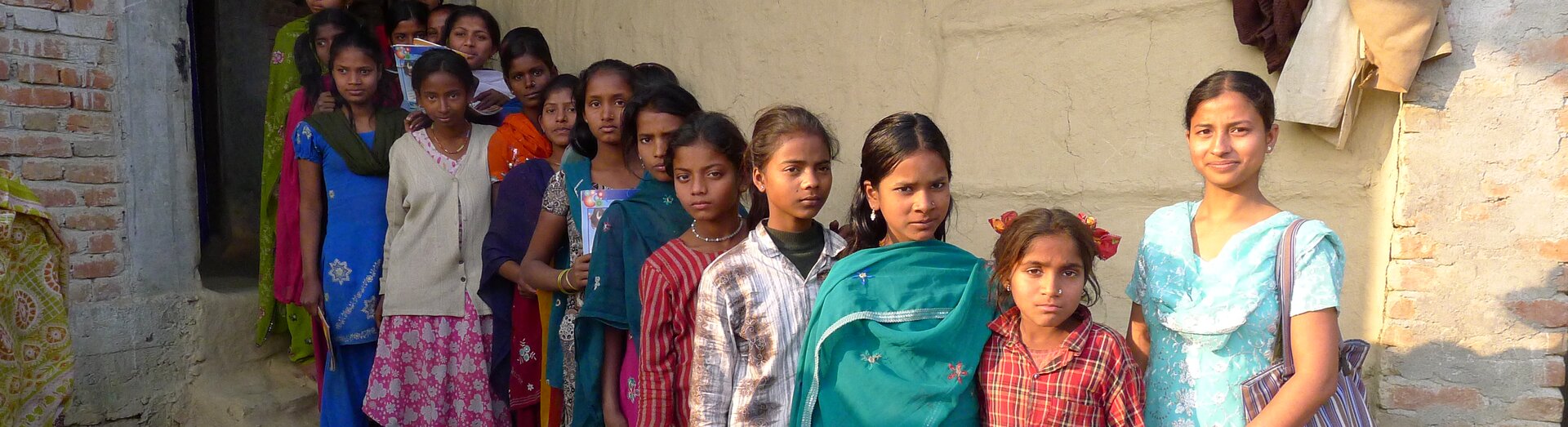 Samvad group of girls from Nepal and their animator standing in line in front of the Samvad centre. 