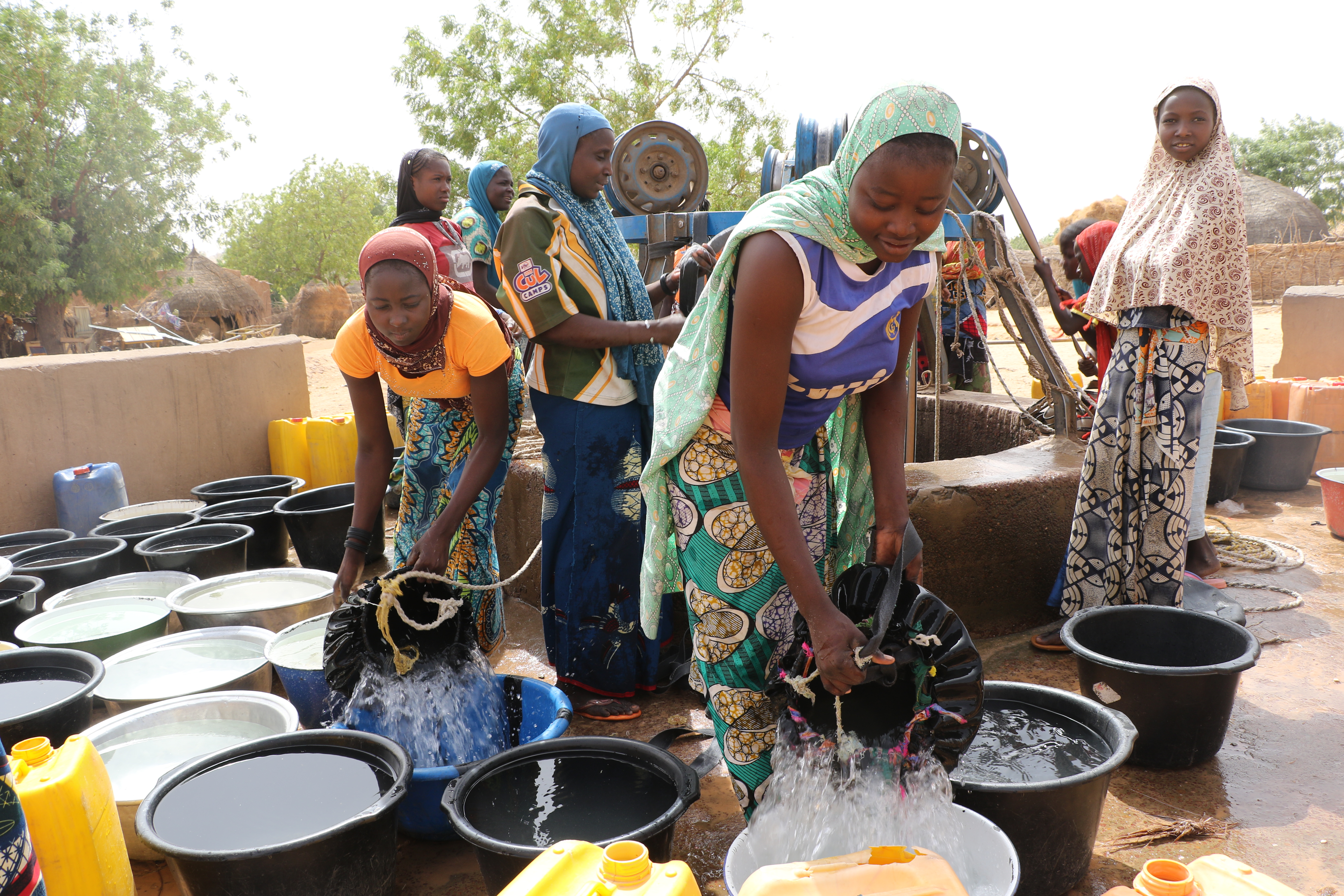 Unge jenter ved en brønn i Niger, en naturlig del av daglige oppgaver i hjemmet. 