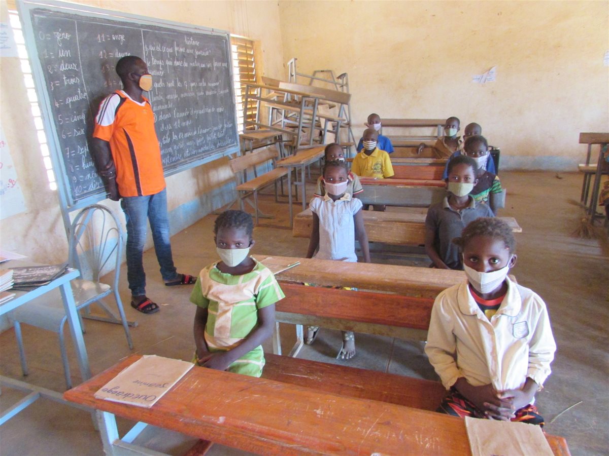 Barn og lærer fra Burkina Faso med munnbind under pandemien